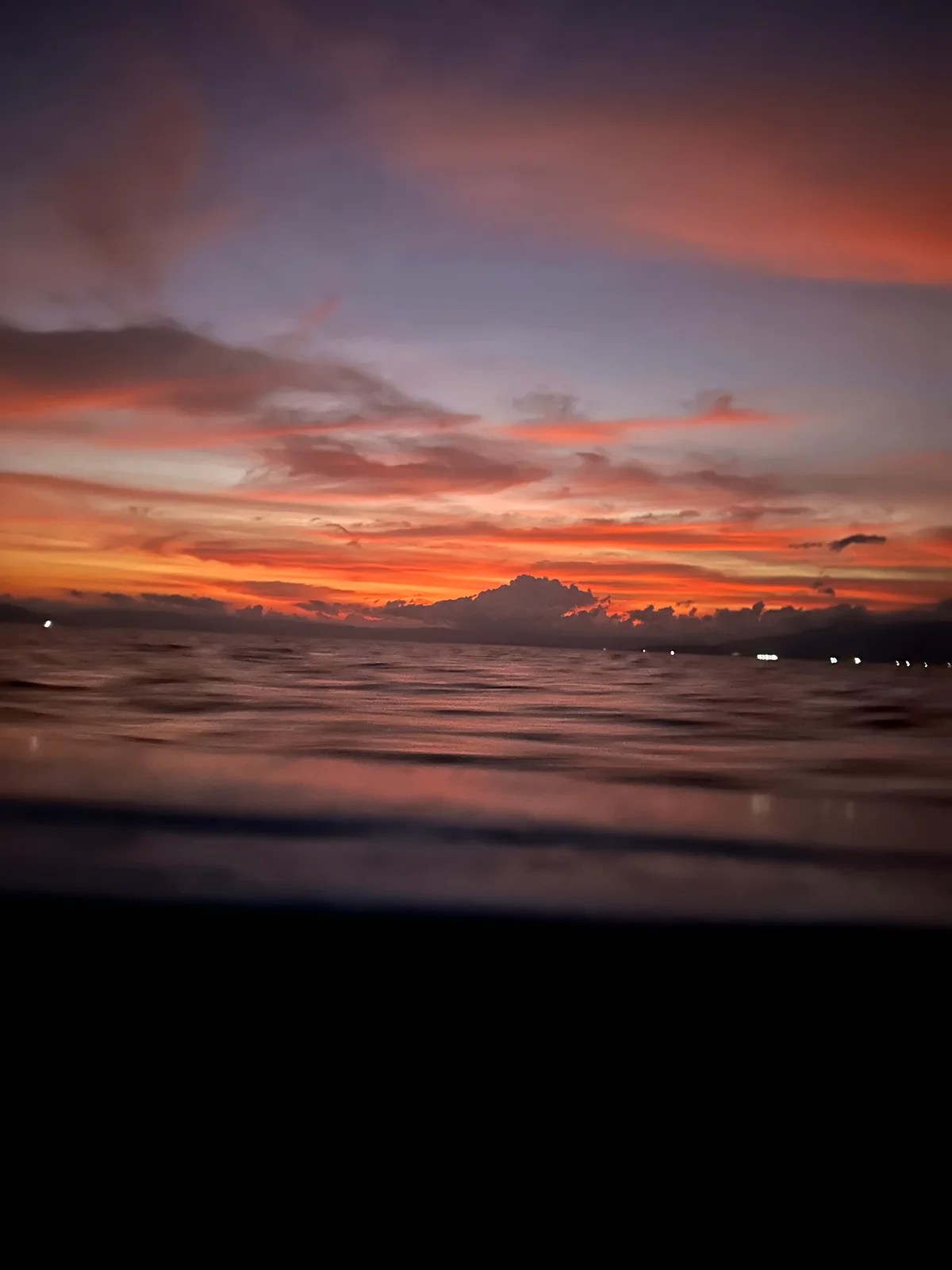 Ein glühender Sonnenuntergang durch einen schmalen Spalt, die Farben verschwimmen in Orange und Rot