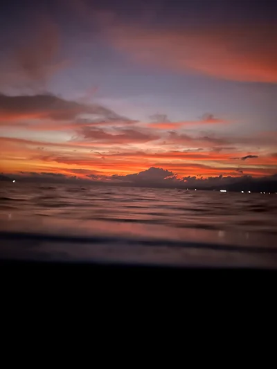 Ein glühender Sonnenuntergang durch einen schmalen Spalt, die Farben verschwimmen in Orange und Rot